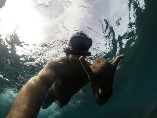 a man taking a selfie underwater with snorkeling gear on